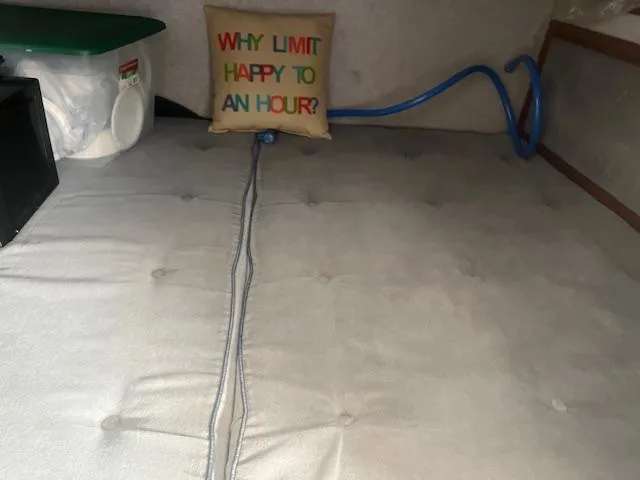 Slide: The Image of 1988 Regal 277 Commodore XL interior with cushion, hose, and storage container. - 24