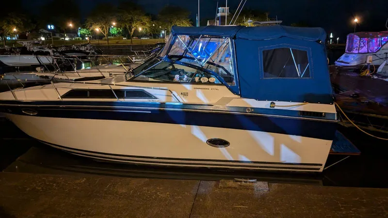Slide: The Image of 1988 Regal 277 Commodore XL boat docked at night with blue canopy. - 3