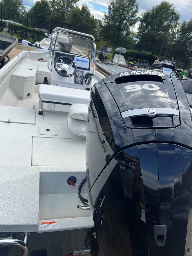 Slide: The Image of 2024 Ranger RB190 boat with Mercury 90 engine, white interior, and steering console. - 2