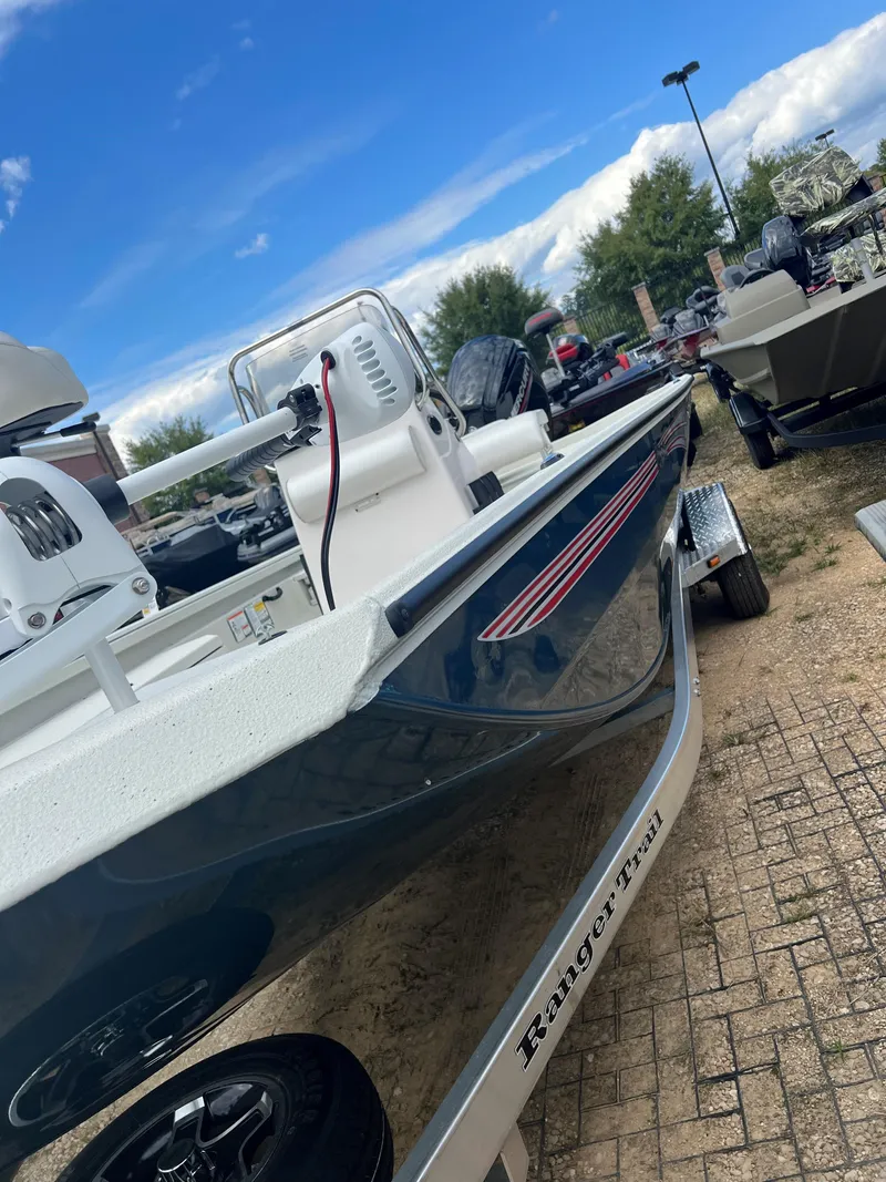 Slide: The Image of 2024 Ranger RB190 boat on trailer, parked outdoors under a blue sky. - 7