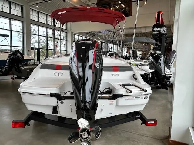Slide: The Image of 2024 Tahoe T18 boat with outboard motor in showroom, featuring red canopy. - 2
