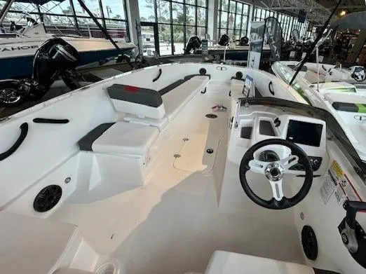 Slide: The Image of 2024 Tahoe T18 boat interior with steering wheel and seating in showroom. - 4