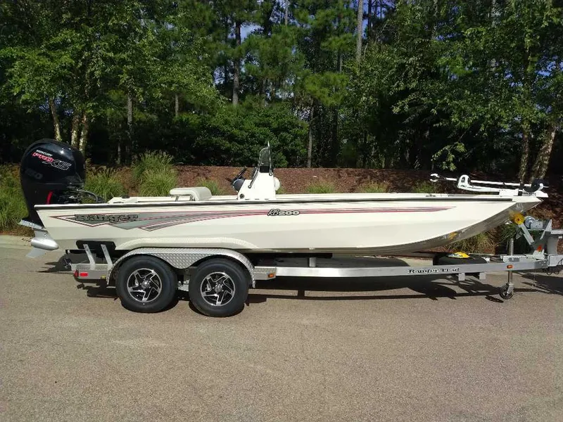 The Image of 2024 Ranger RB200 boat on trailer, parked outdoors, surrounded by trees. - 0