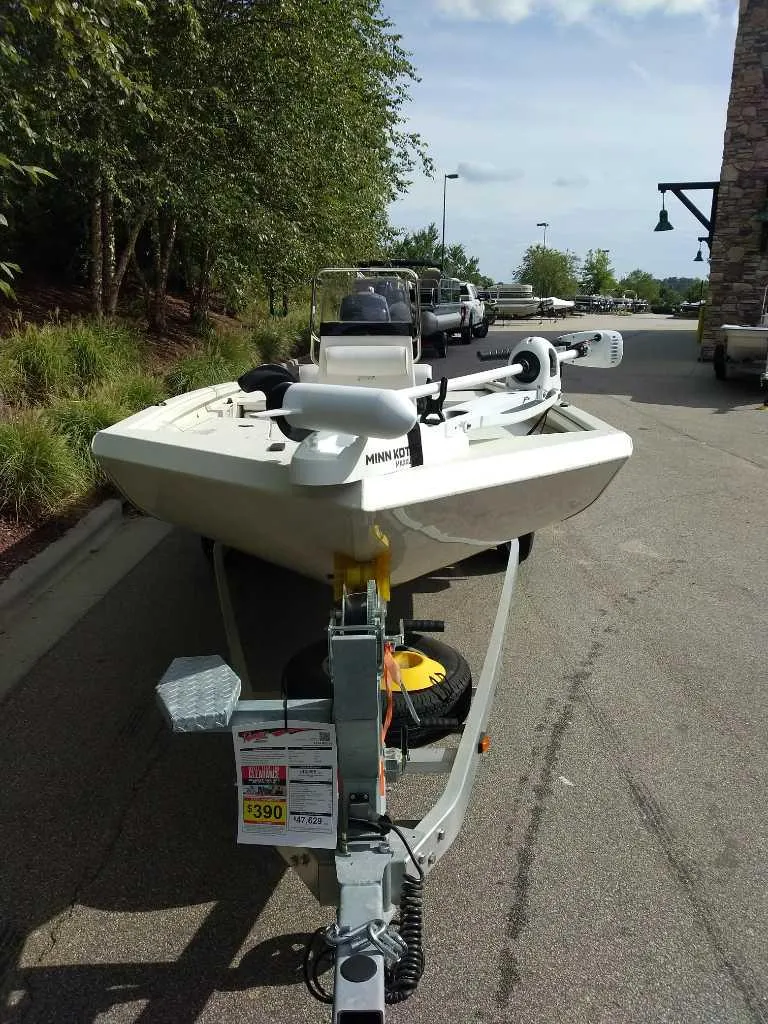 Slide: The Image of 2024 Ranger RB200 boat on trailer, parked outdoors near trees and buildings. - 1