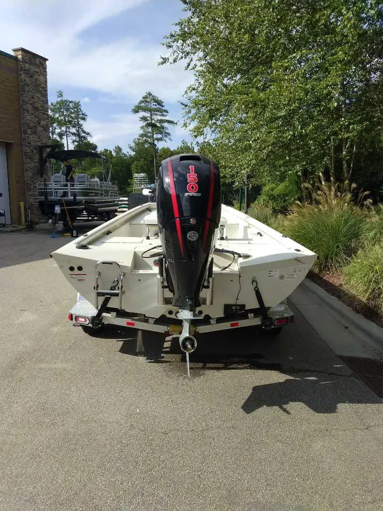 Slide: The Image of 2024 Ranger RB200 boat with outboard motor, parked outdoors on a sunny day. - 2