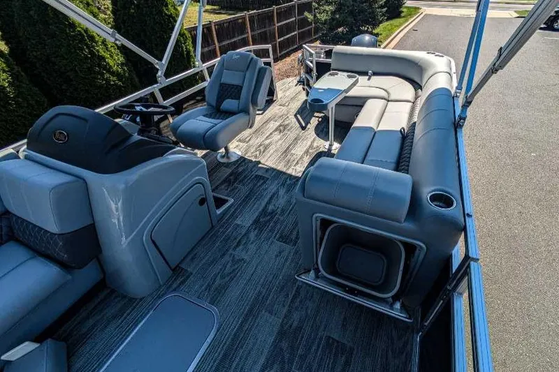 Slide: The Image of 2024 Ranger Reata 223C pontoon boat interior with plush seating and modern design. - 2