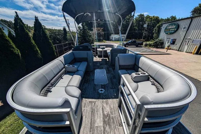 Slide: The Image of 2024 Ranger Reata 223C pontoon boat with spacious seating and canopy, parked outdoors. - 3