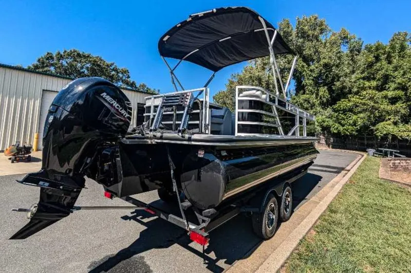 Slide: The Image of 2024 Ranger Reata 223C pontoon boat with canopy on trailer, parked outdoors. - 4