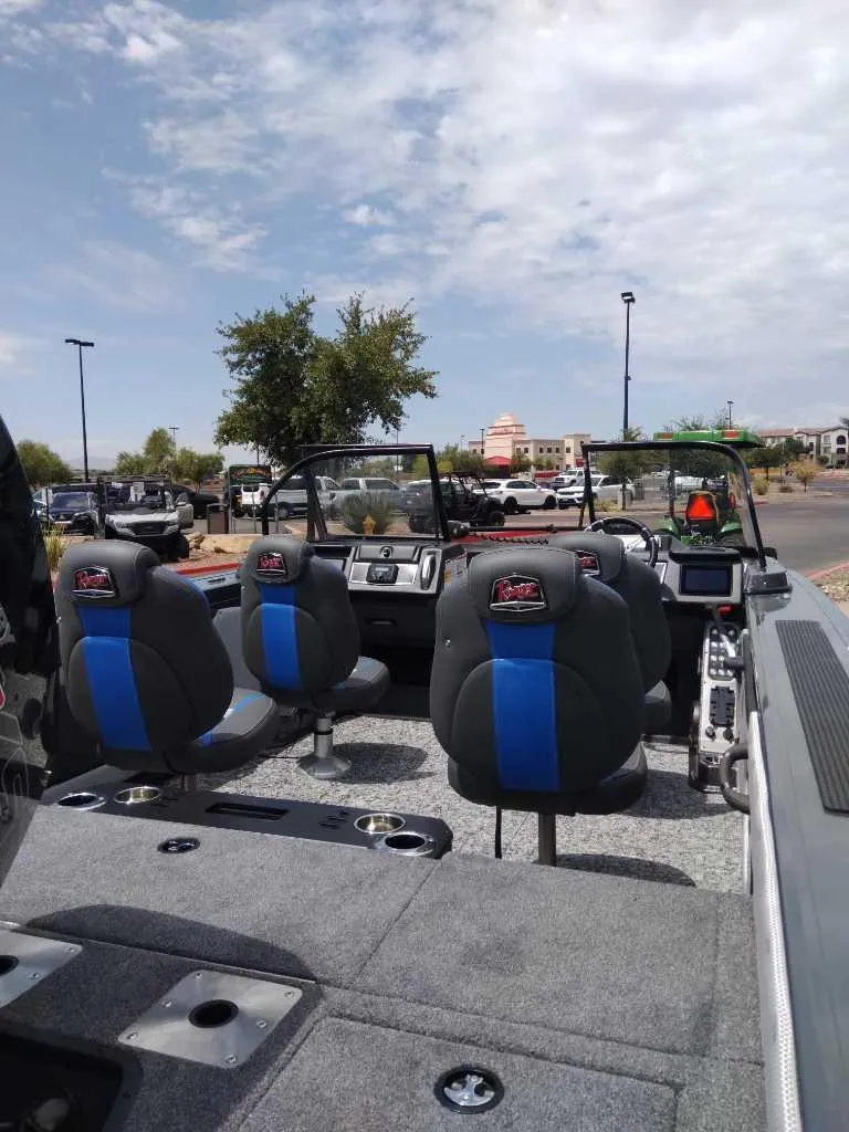 Slide: The Image of 2024 Ranger VX1988 WT boat interior with seating and dashboard under cloudy sky. - 4