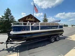 The Image of 2024 Ranger Reata 200F boat on trailer outside Cabela's store. - 0