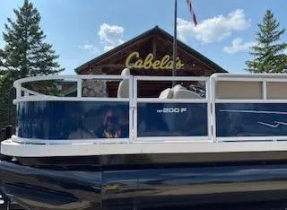 Slide: The Image of 2024 Ranger Reata 200F boat parked outside Cabela's store. - 1