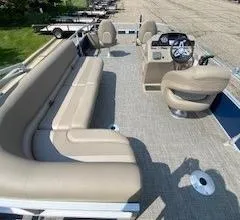 Slide: The Image of 2024 Ranger Reata 200F pontoon boat interior with beige seating and steering console. - 8