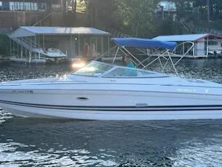 Slide: The Image of 1999 Formula 280 Bowrider boat on a calm lake with a blue canopy. - 1