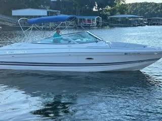 Slide: The Image of 1999 Formula 280 Bowrider boat cruising on a lake with a blue canopy. - 2