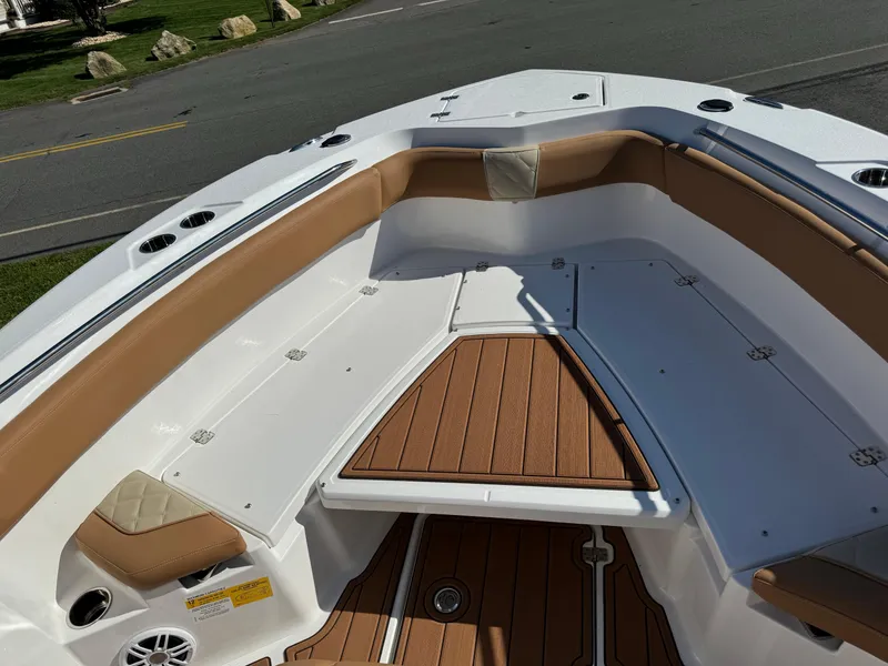 Slide: The Image of 2025 NauticStar 24 OSL boat interior with tan seating and wood accents. - 10