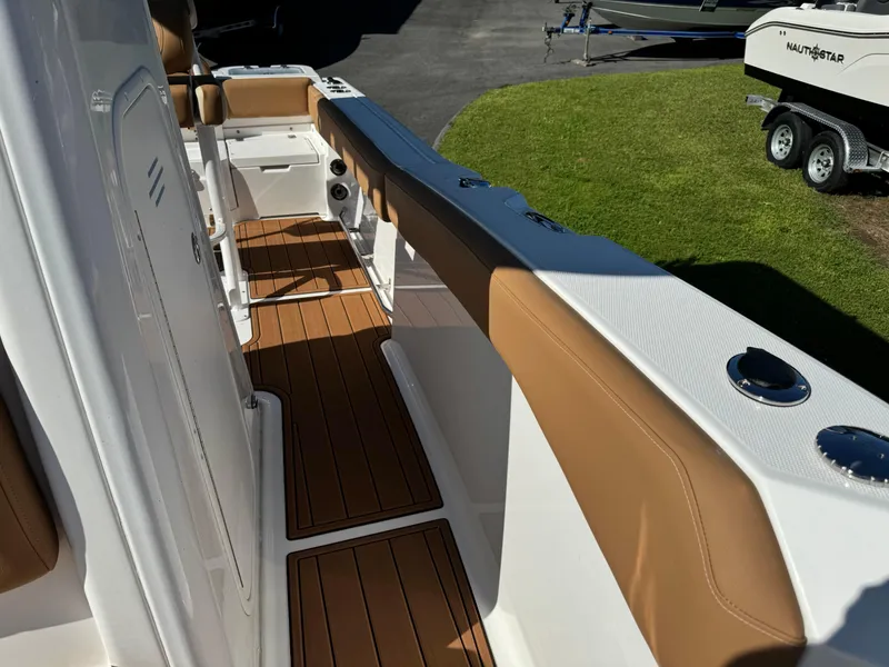 Slide: The Image of 2025 NauticStar 24 OSL boat interior with tan seating and wood flooring. - 16