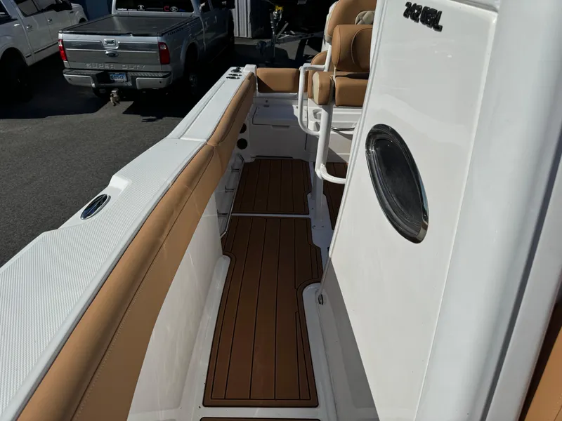 Slide: The Image of 2025 NauticStar 24 OSL boat interior with tan seating and wood flooring. - 17