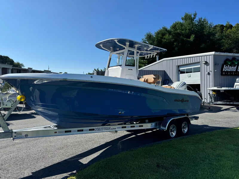 Slide: The Image of 2025 NauticStar 24 OSL boat on trailer, parked outside a marina. - 4