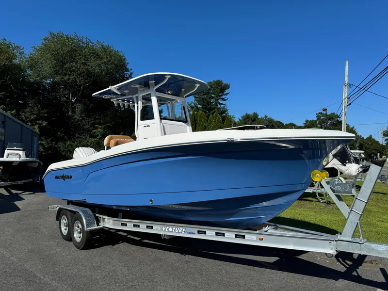 Slide: The Image of 2025 NauticStar 24 OSL boat on trailer, blue hull, parked outdoors. - 5
