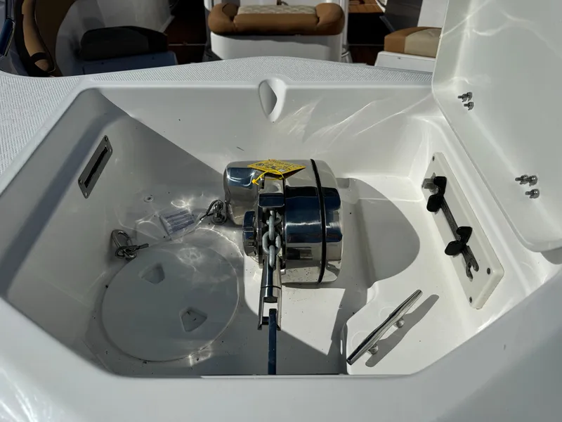 Slide: The Image of Anchor compartment of 2025 NauticStar 24 OSL boat, featuring a winch and chain. - 7