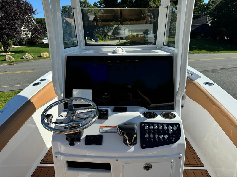 Slide: The Image of 2025 NauticStar 24 OSL boat dashboard with steering wheel and control panel. - 9