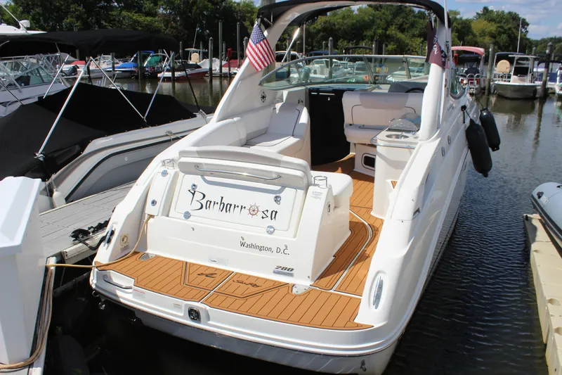 The Image of 2012 Sea Ray 280 Sundancer boat docked, featuring teak deck and American flag. - 1