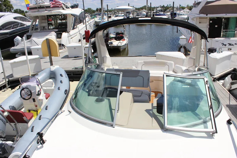 Slide: The Image of 2012 Sea Ray 280 Sundancer docked at marina, featuring open deck and seating area. - 18