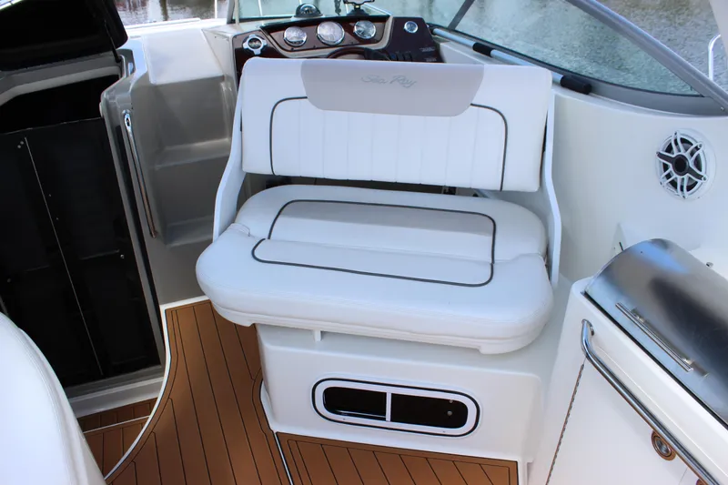 Slide: The Image of 2012 Sea Ray 280 Sundancer cockpit with white seating and wood-style flooring. - 21