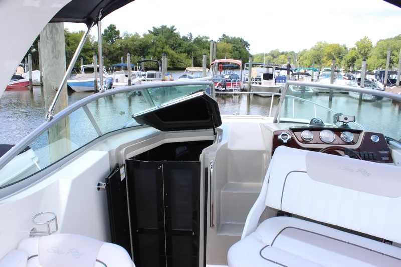 Slide: The Image of 2012 Sea Ray 280 Sundancer boat interior at marina, featuring helm and seating area. - 22