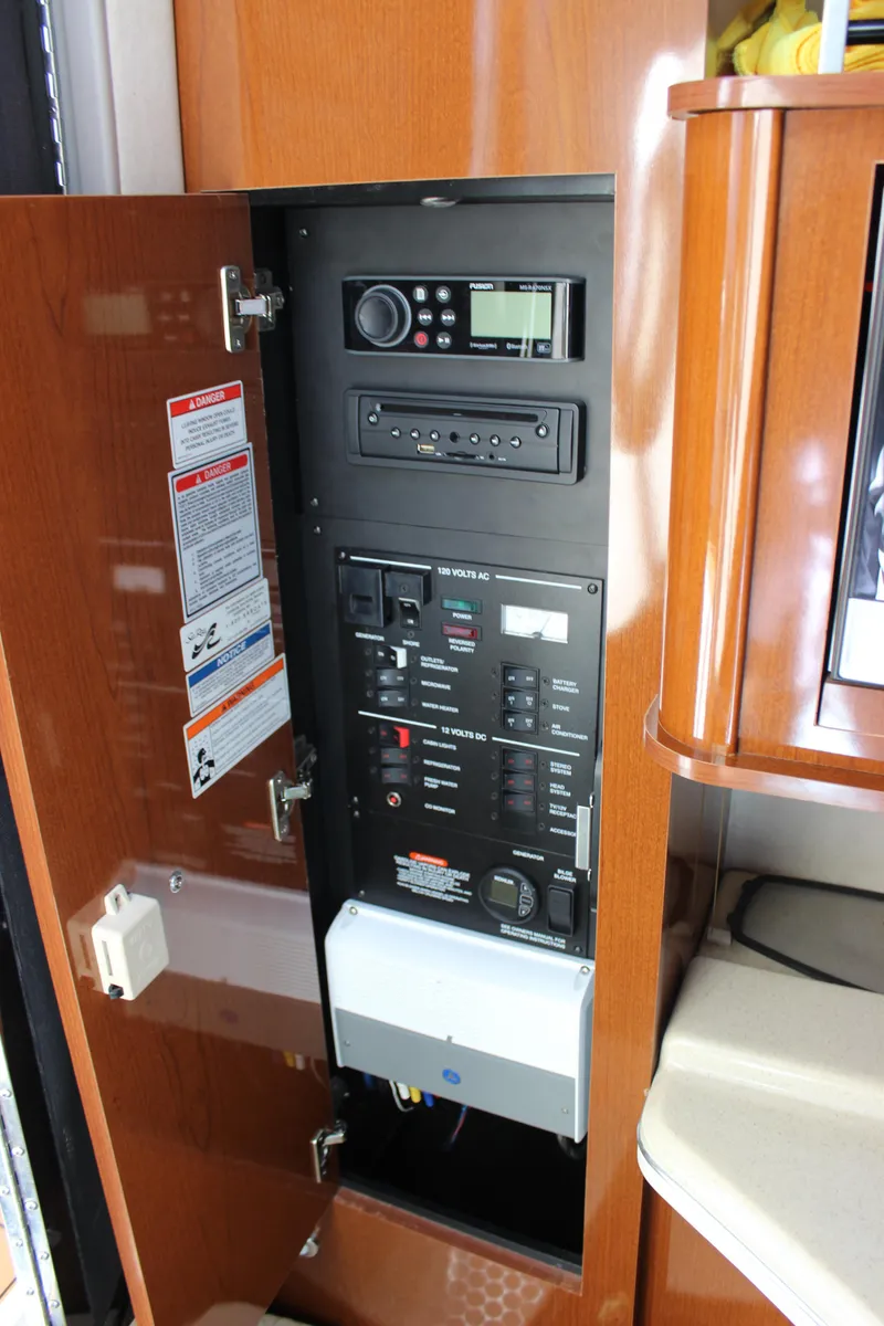 Slide: The Image of Control panel inside a 2012 Sea Ray 280 Sundancer boat, featuring various switches and a radio. - 23