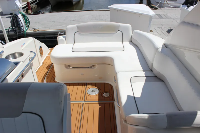 Slide: The Image of 2012 Sea Ray 280 Sundancer boat interior with white seating and wooden deck. - 9