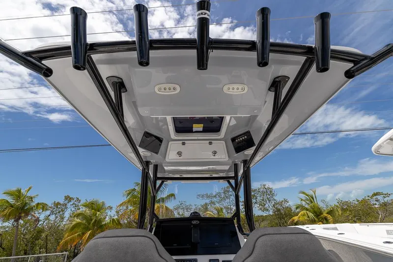 Slide: The Image of 2024 Sea Fox 288 Commander boat with T-top and rod holders under a clear blue sky. - 11