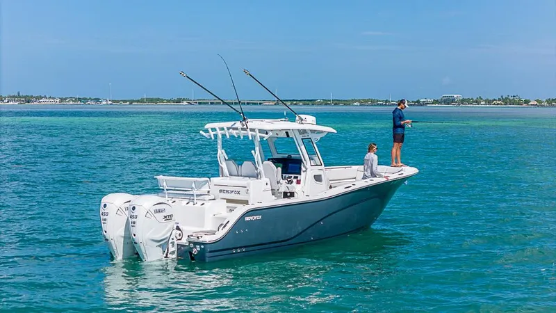 Slide: The Image of 2024 Sea Fox 328 Commander boat on clear blue water, two people fishing. - 12