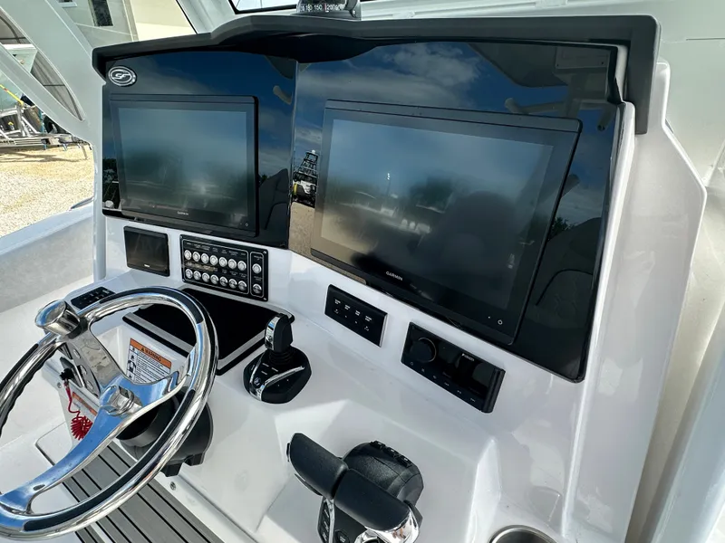 Slide: The Image of 2024 Sea Fox 328 Commander dashboard with dual screens and steering wheel. - 16