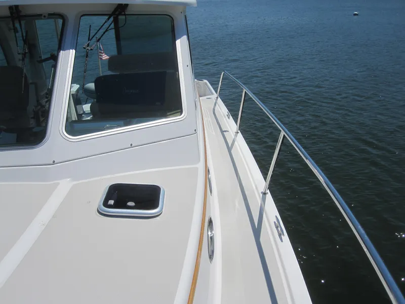 Slide: The Image of 2014 Back Cove 34 Hard Top boat on water, featuring sleek deck and railing. - 17