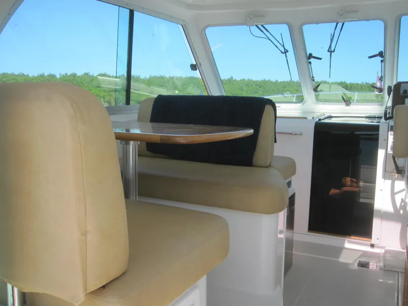 Slide: The Image of Interior of 2014 Back Cove 34 Hard Top boat with beige seating and table. - 24