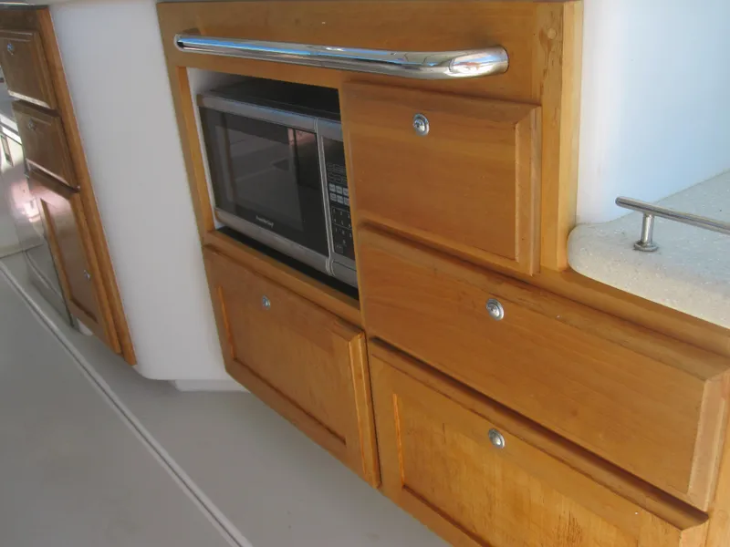 Slide: The Image of Wooden cabinetry with built-in microwave on 2014 Back Cove 34 Hard Top/Hard Back boat. - 25