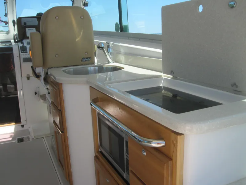 Slide: The Image of 2014 Back Cove 34 Hard Top interior with kitchenette, sink, and microwave. - 26