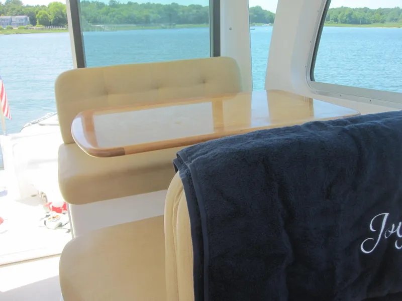 Slide: The Image of Interior of 2014 Back Cove 34 Hard Top, featuring seating and table with lake view. - 27