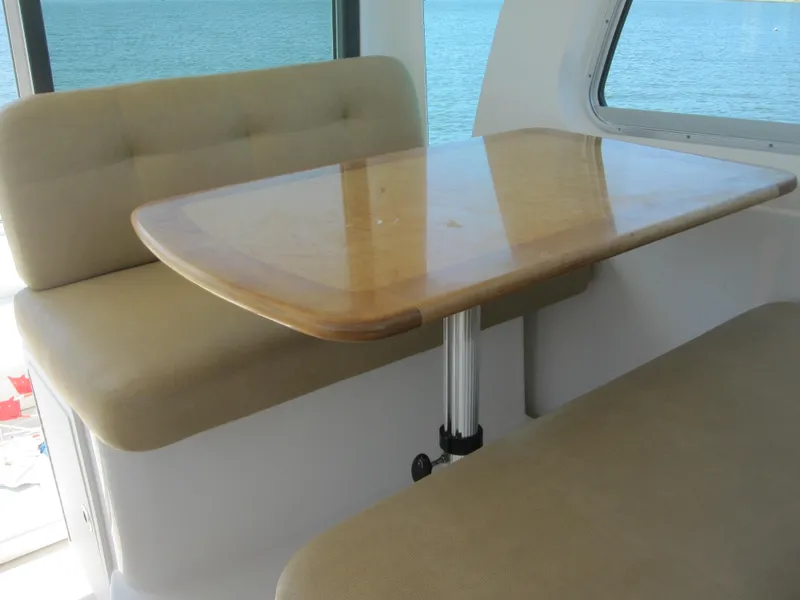 Slide: The Image of Interior of 2014 Back Cove 34, featuring a wooden table and cushioned seating. - 29