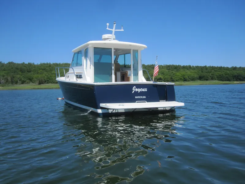 Slide: The Image of 2014 Back Cove 34 Hard Top boat on calm water, clear sky background. - 3