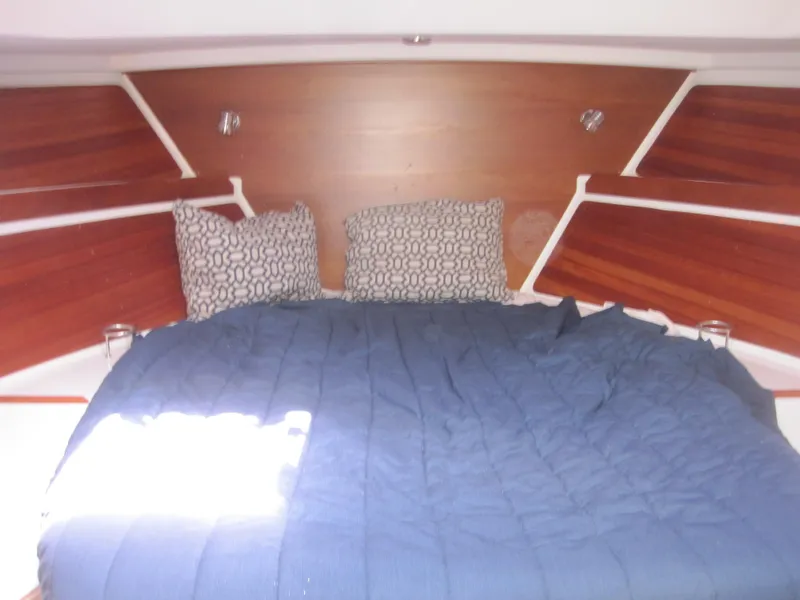 Slide: The Image of Cozy cabin interior of 2014 Back Cove 34 with blue bedding and patterned pillows. - 46