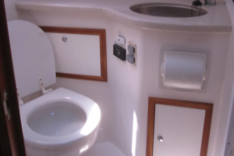 Slide: The Image of 2014 Back Cove 34 yacht bathroom with toilet, sink, and storage cabinets. - 49