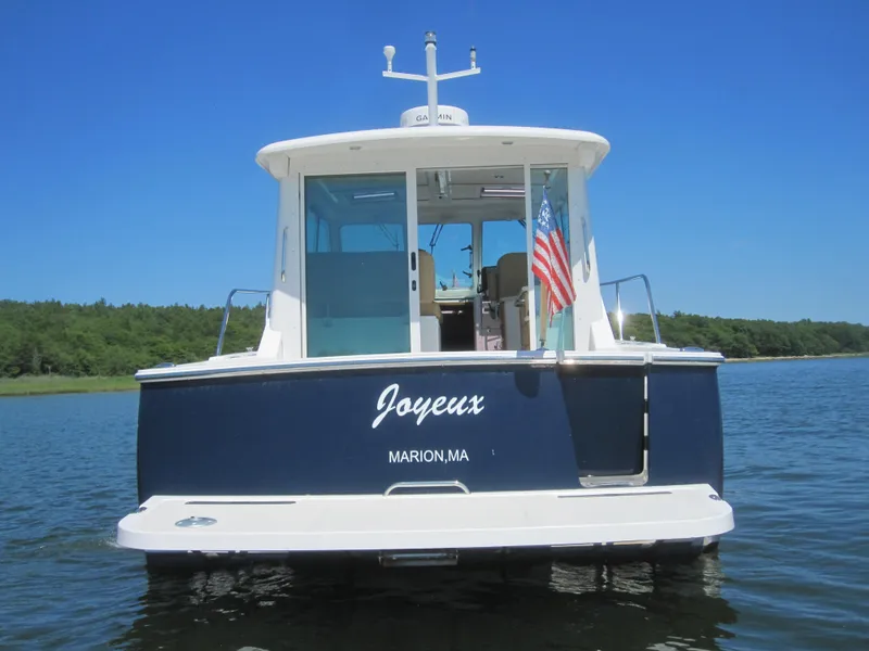 Slide: The Image of 2014 Back Cove 34 Hard Top boat on water, rear view, American flag displayed. - 5