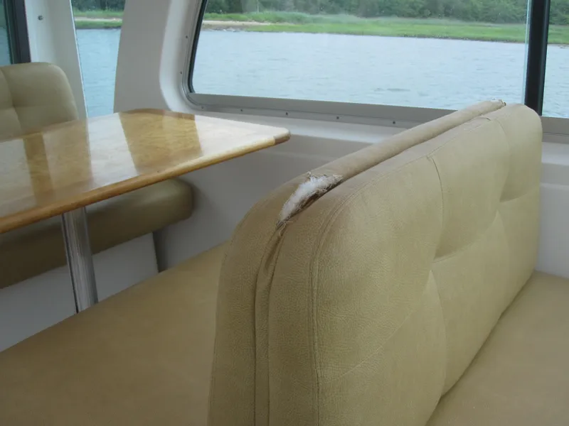 Slide: The Image of Interior of 2014 Back Cove 34 boat with beige seating and wooden table. - 58