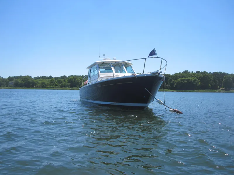 Slide: The Image of 2014 Back Cove 34 Hard Top boat anchored on calm water. - 7