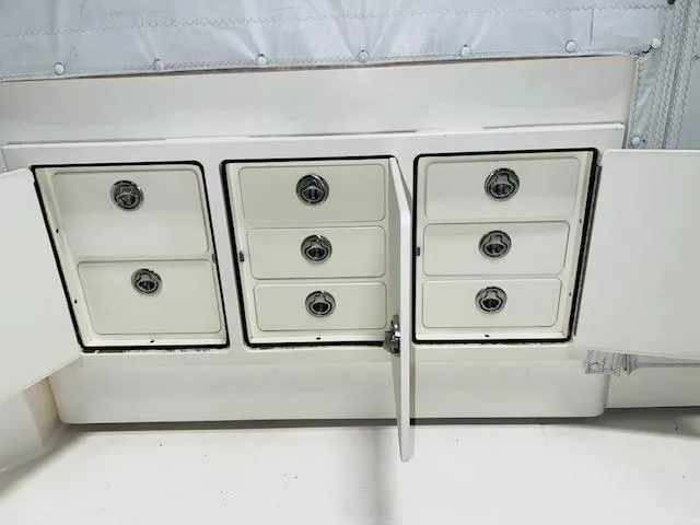 Slide: The Image of 2006 Carolina Classic 28 boat storage compartments with open doors. - 12