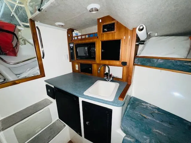 Slide: The Image of 2006 Carolina Classic 28 boat interior with kitchenette and bunk beds. - 15
