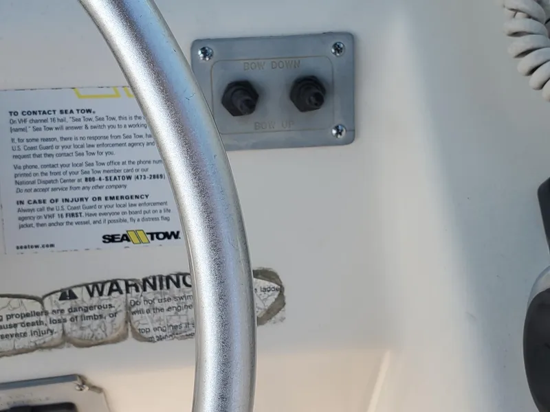 Slide: The Image of Close-up of 1999 Pursuit 2470 Walkaround boat controls and warning labels. - 11