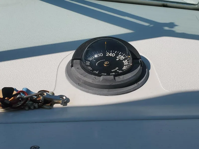 Slide: The Image of Compass on 1999 Pursuit 2470 Walkaround boat dashboard in sunlight. - 12